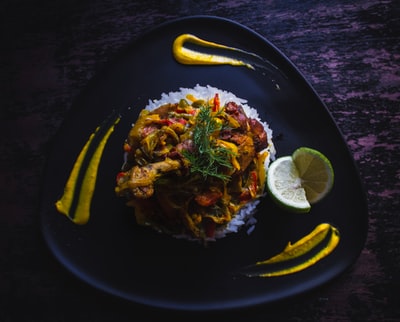 Black plate of cooked food
